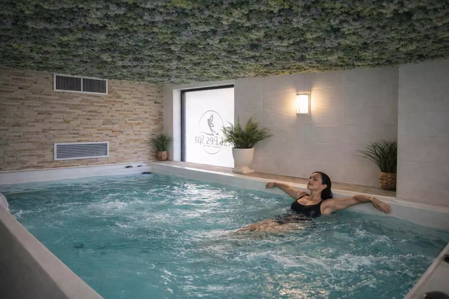 Femme se relaxant dans un bassin de nage intérieur dans un spa
